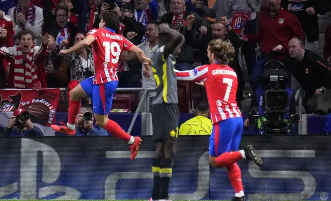 Atletico Madrid's Julian Alvarez, left, celebrates with Atletico Madrid's Antoine Griezmann after scoring his sides first goal during the Champions League opening phase soccer match between Atletico Madrid and Lille at the Metropolitano stadium in Madrid, Spain, Wednesday, Oct. 23, 2024. (AP Photo/Manu Fernandez)