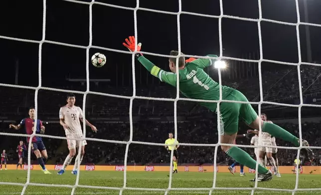 Barcelona's Raphinha, unseen, scores his side's third goal past Bayern's goalkeeper Manuel Neuer during the Champions League opening phase soccer match between Barcelona and Bayern Munich at the Lluis Companys Olympic Stadium in Barcelona, Spain, Wednesday, Oct. 23, 2024. (AP Photo/Emilio Morenatti)