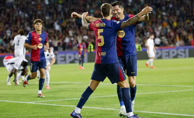 Barcelona's Robert Lewandowski, right, celebrates after scoring his side's fourth goal during the Champions League soccer match between Barcelona and Young Boys at the Lluis Companys Olympic Stadium in Barcelona, Spain, Tuesday, Oct. 1, 2024. (AP Photo/Joan Monfort)