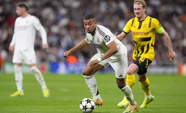 Real Madrid's Kylian Mbappe plays the ball during the Champions League opening phase soccer match between Real Madrid and Borussia Dortmund at the Santiago Bernabeu stadium in Madrid, Tuesday, Oct. 22, 2024. Real Madrid won 5-2. (AP Photo/Manu Fernandez)