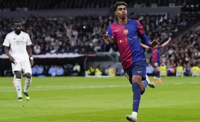 Barcelona's Lamine Yamal celebrates after scoring his side's third goal during a Spanish La Liga soccer match between Real Madrid and Barcelona at the Santiago Bernabeu stadium in Madrid, Spain, Saturday, Oct. 26, 2024. (AP Photo/Manu Fernandez)