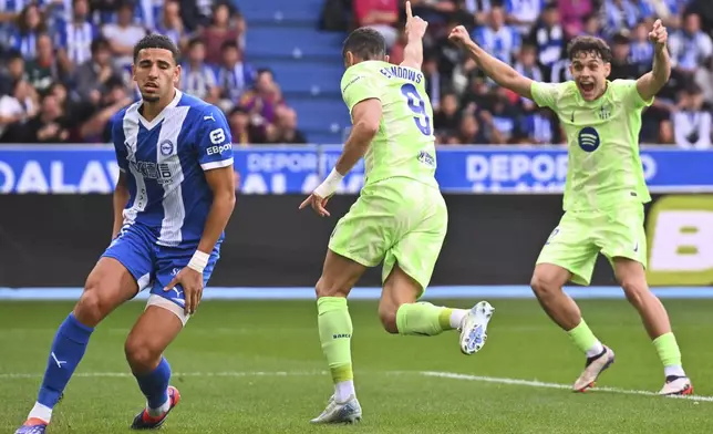 Barcelona's Robert Lewandowski, center, celebrates after scoring the opening goal against Alaves during a Spanish La Liga soccer match at the Mendizorroza stadium in Vitoria-Gasteiz, Spain, Sunday, Oct. 6, 2024. (AP Photo/Miguel Oses)