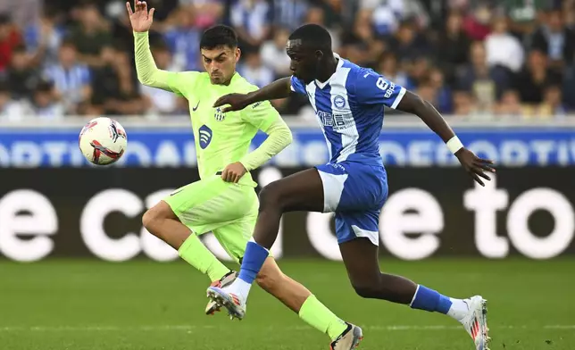 Alaves' Moussa Diarra, right, and Barcelona's Pedri battle for the ball during a Spanish La Liga soccer match at the Mendizorroza stadium in Vitoria-Gasteiz, Spain, Sunday, Oct. 6, 2024. (AP Photo/Miguel Oses)