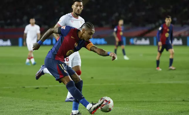 Barcelona's Raphinha kicks the ball during a Spanish La Liga soccer match between Barcelona and Sevilla at the Olimpic Lluis Companys stadium in Barcelona, Spain, Sunday, Oct. 20, 2024. (AP Photo/Joan Monfort)