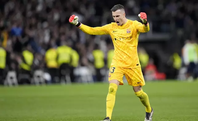Barcelona's goalkeeper Inaki Pena celebrates de second goal scored by Robert Lewandowski during a Spanish La Liga soccer match between Real Madrid and Barcelona at the Santiago Bernabeu stadium in Madrid, Spain, Saturday, Oct. 26, 2024. (AP Photo/Bernat Armangue)