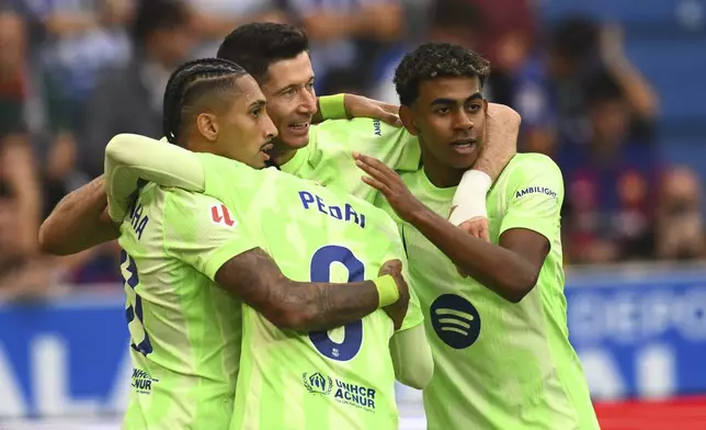 Barcelona's Robert Lewandowski, center, celebrates after scoring his side's 2nd goal against Alaves during a Spanish La Liga soccer match at the Mendizorroza stadium in Vitoria-Gasteiz, Spain, Sunday, Oct. 6, 2024. (AP Photo/Miguel Oses)