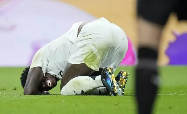 Real Madrid's Vinicius Junior grimaces in pain during the La Liga soccer match between Real Madrid and Villareal in Madrid, Spain, on Saturday, Oct. 5, 2024. (AP Photo/Bernat Armangue)