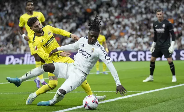 Real Madrid's Eduardo Camavinga falls in front of Villarreal's Alex Baena during the La Liga soccer match between Real Madrid and Villareal in Madrid, Spain, on Saturday, Oct. 5, 2024. (AP Photo/Bernat Armangue)