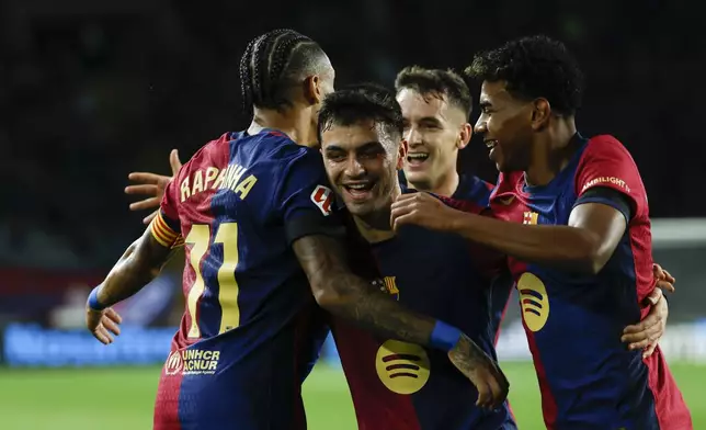 Barcelona's Pedri, center, celebrates with teammates after scoring his side's second goal during a Spanish La Liga soccer match between Barcelona and Sevilla at the Olimpic Lluis Companys stadium in Barcelona, Spain, Sunday, Oct. 20, 2024. (AP Photo/Joan Monfort)