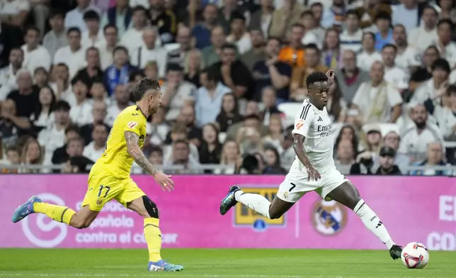 Real Madrid's Vinicius Junior in action in front of Villarreal's Kiko Femenia during the La Liga soccer match between Real Madrid and Villareal in Madrid, Spain, on Saturday, Oct. 5, 2024. (AP Photo/Bernat Armangue)