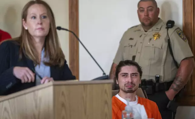 FILE - Ryan Martinez, seated, cries during his preliminary and detention hearing in Tierra Amarilla, N.M., Friday, Oct. 13, 2023, as his attorney Nicole Moss, describes the events that led to him allegedly shooting Jacob Johns during a rally outside the Rio Arriba County Complex in Espanola. (Eddie Moore/The Albuquerque Journal via AP, File)