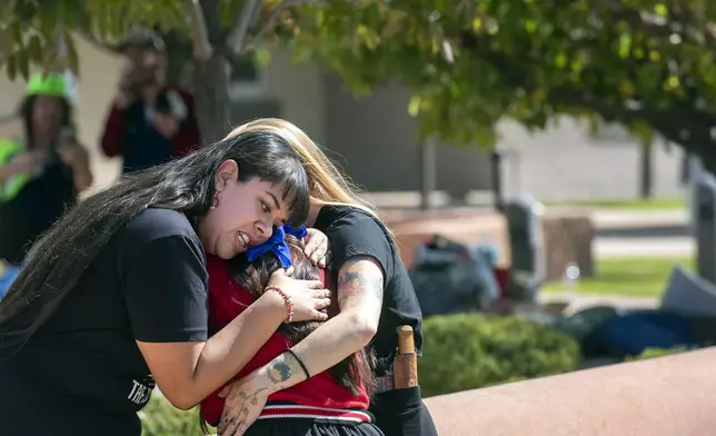 FILE - Jennifer Marley, San Ildefonso Pueblo, and others hug after a man was shot during a rally to protest a statue of Juan Onate that was to be resurrected outside the Rio Arriba County building, in Espanola, N.M., Thursday, Sept. 28, 2023. (Eddie Moore/The Albuquerque Journal via AP, File)