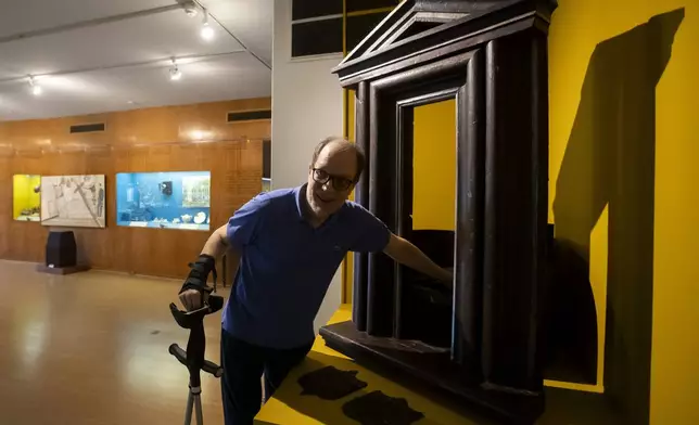 Paulo Knauss, 58, director of the Museum of the Brazilian Historical and Geographical Institute, shows how to use the "wheel of the exposed" or "wheel of the foundlings," a 1738 mechanism used to deposit newborns for charitable institutions, at the Museum of the Brazilian Historical and Geographical Institute in Rio de Janeiro, Friday, Oct. 25, 2024. (AP Photo/Bruna Prado)