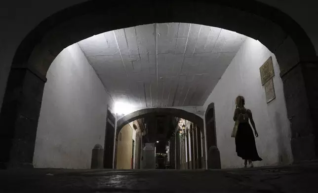 A woman walks in an important Brazilian historical construction from the 18th century named Arco do Teles, in Rio de Janeiro, Friday, Oct. 25, 2024. (Bruna Prado/AP Photo)