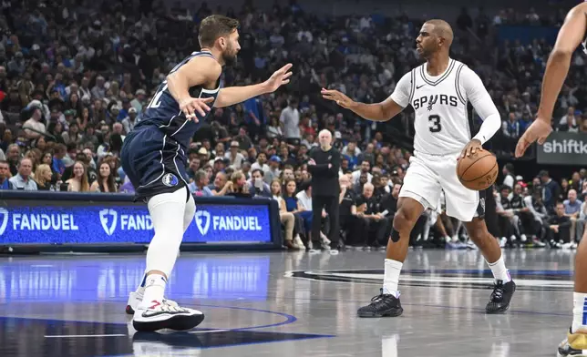 San Antonio Spurs' Chris Paul (3) is defended by Dallas Mavericks forward Maxi Kleber, left, during the first half of an NBA basketball game, Thursday, Oct. 24, 2024, in Dallas, Texas. (AP Photo/Albert Pena)