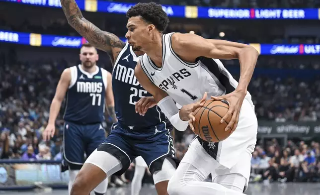 San Antonio Spurs' center Victor Wembanyama, foreground, drives to the basket during the first half of an NBA basketball game against the Dallas Mavericks, Thursday, Oct. 24, 2024, in Dallas, Texas. (AP Photo/Albert Pena)