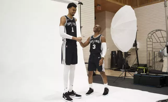 San Antonio Spurs players Victor Wembanyama (1) and Chris Paul (3) pose for photos during the NBA basketball team's media day, Monday, Sept. 30, 2024, in San Antonio. (AP Photo/Darren Abate)