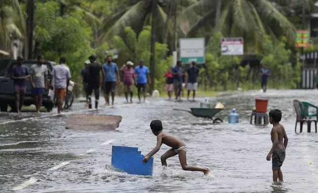 Children play in a flooded street in Colombo, Sri Lanka, Sunday, Oct. 13, 2024. (AP Photo/Eranga Jayawardena)