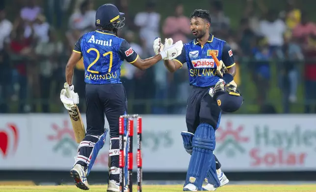 Sri Lanka's Kamindu Mendis, left, and Janith Liyanage celebrate their team's win in the first ODI cricket match between Sri Lanka and West Indies in Pallekele, Sri Lanka, Sunday, Oct. 20, 2024. (AP Photo/Viraj Kothalawala)