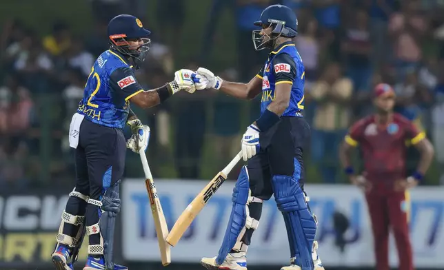 Sri Lanka's Captain Charith Asalanka, left, and Nishan Madushka, bump fists during the first ODI cricket match between Sri Lanka and West Indies in Pallekele, Sri Lanka, Sunday, Oct. 20, 2024. (AP Photo/Viraj Kothalawala)