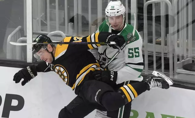 Boston Bruins center Charlie Coyle (13) and Dallas Stars defenseman Thomas Harley (55) slam into the boards in the first period of an NHL hockey game, Thursday, Oct. 24, 2024, in Boston. (AP Photo/Steven Senne)