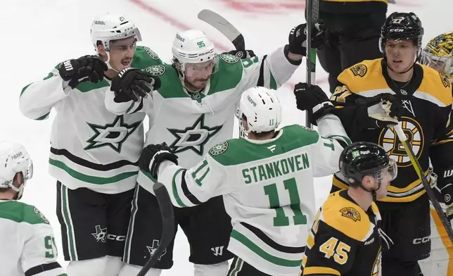 Dallas Stars center Logan Stankoven (11) celebrates with left wing Mason Marchment, top left, and center Matt Duchene (95) after scoring in front of Boston Bruins defenseman Hampus Lindholm, upper right, and left wing Cole Koepke (45) in the second period of an NHL hockey game, Thursday, Oct. 24, 2024, in Boston. (AP Photo/Steven Senne)