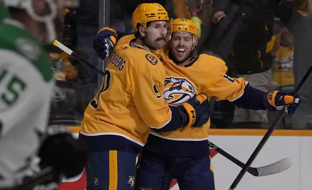 Nashville Predators left wing Filip Forsberg (9) celebrates his goal with center Jonathan Marchessault (81) during the second period of an NHL hockey game against the Dallas Stars, Thursday, Oct. 10, 2024, in Nashville, Tenn. (AP Photo/George Walker IV)