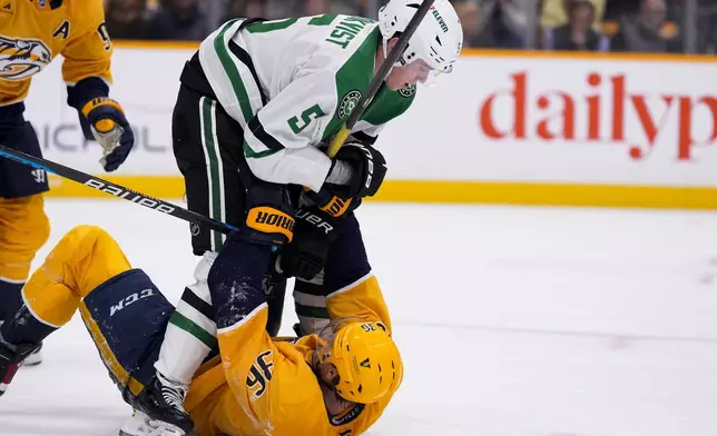 Dallas Stars defenseman Nils Lundkvist (5) and Nashville Predators left wing Cole Smith (36) fight during the second period of an NHL hockey game Thursday, Oct. 10, 2024, in Nashville, Tenn. (AP Photo/George Walker IV)