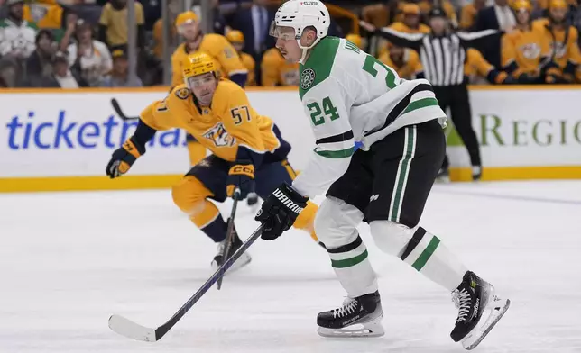 Dallas Stars center Roope Hintz (24) skates the puck past Nashville Predators defenseman Dante Fabbro (57) during the first period of an NHL hockey game Thursday, Oct. 10, 2024, in Nashville, Tenn. (AP Photo/George Walker IV)