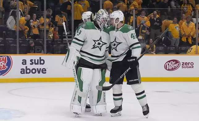 Dallas Stars defenseman Ilya Lyubushkin, right, congratulates goaltender Jake Oettinger, left, after the team's 4-3 win against the Nashville Predators in an NHL hockey game Thursday, Oct. 10, 2024, in Nashville, Tenn. (AP Photo/George Walker IV)