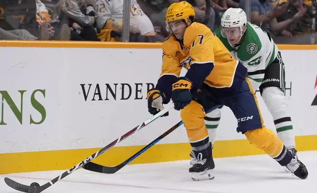 Nashville Predators right wing Luke Evangelista (77) skates the puck past Dallas Stars defenseman Esa Lindell (23) during the second period of an NHL hockey game Thursday, Oct. 10, 2024, in Nashville, Tenn. (AP Photo/George Walker IV)