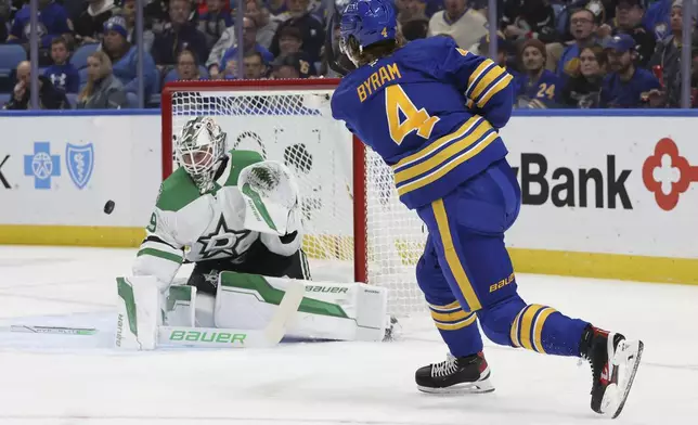 Buffalo Sabres defenseman Bowen Byram (4) shoots the puck wide past Dallas Stars goaltender Jake Oettinger (29) during the first period of an NHL hockey game, Tuesday, Oct. 22, 2024, in Buffalo, N.Y. (AP Photo/Jeffrey T. Barnes)