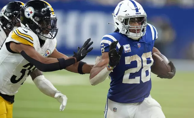 Indianapolis Colts running back Jonathan Taylor (28) carries the ball with Pittsburgh Steelers safety Minkah Fitzpatrick defending during the second half of an NFL football game, Sunday, Sept. 29, 2024, in Indianapolis. (AP Photo/Michael Conroy)