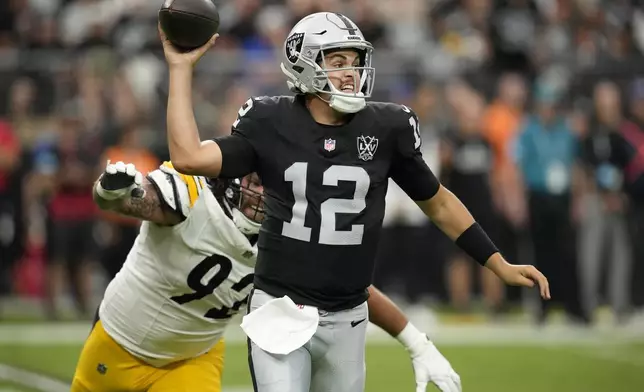 Las Vegas Raiders quarterback Aidan O'Connell (12) passes as Pittsburgh Steelers defensive tackle Isaiahh Loudermilk (92) applies pressure during the first half of an NFL football game in Las Vegas, Sunday, Oct. 13, 2024. (AP Photo/John Locher)