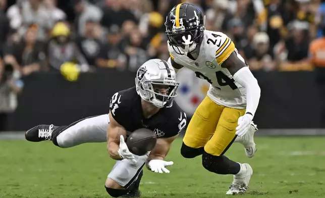 Las Vegas Raiders wide receiver Alex Bachman, bottom, catches a pass in front of Pittsburgh Steelers cornerback Joey Porter Jr. (24) during the first half of an NFL football game in Las Vegas, Sunday, Oct. 13, 2024. (AP Photo/David Becker)