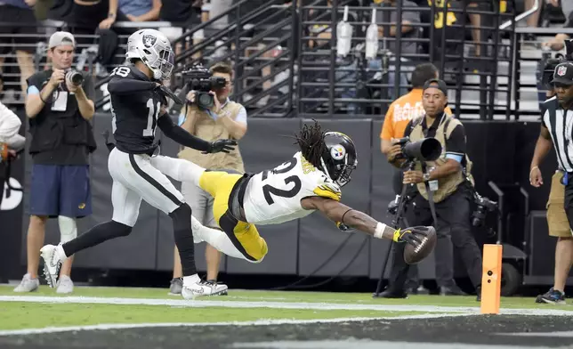 Pittsburgh Steelers running back Najee Harris (22) dives for a touchdown past Las Vegas Raiders cornerback Jack Jones (18) during the second half of an NFL football game at Allegiant Stadium Sunday, Oct. 13, 2024, in Las Vegas. (Steve Marcus/Las Vegas Sun via AP)