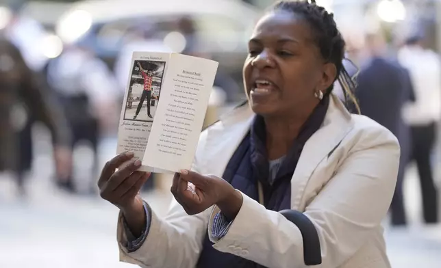 A woman yells and holds up a picture of Jordan Neely just before Daniel Penny arrives to Manhattan criminal court in New York, Monday, Oct. 21, 2024. (AP Photo/Seth Wenig)