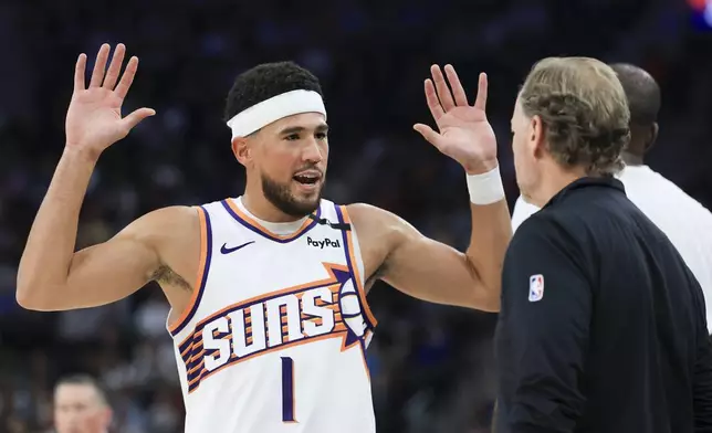 Phoenix Suns guard Devin Booker, left, reacts while speaking to head coach Mike Budenholzer during the first half of an NBA basketball game against the LA Clippers, Wednesday, Oct. 23, 2024, in Inglewood, Calif. (AP Photo/Ryan Sun)