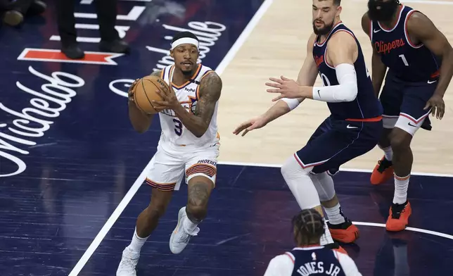 Phoenix Suns guard Bradley Beal, left, drives against LA Clippers center Ivica Zubac, center, and guard James Harden during the first half of an NBA basketball game Wednesday, Oct. 23, 2024, in Inglewood, Calif. (AP Photo/Ryan Sun)