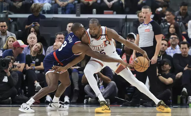 LA Clippers guard Kris Dunn, left, guards Phoenix Suns forward Kevin Durant during the first half of an NBA basketball game, Wednesday, Oct. 23, 2024, in Inglewood, Calif. (AP Photo/Ryan Sun)