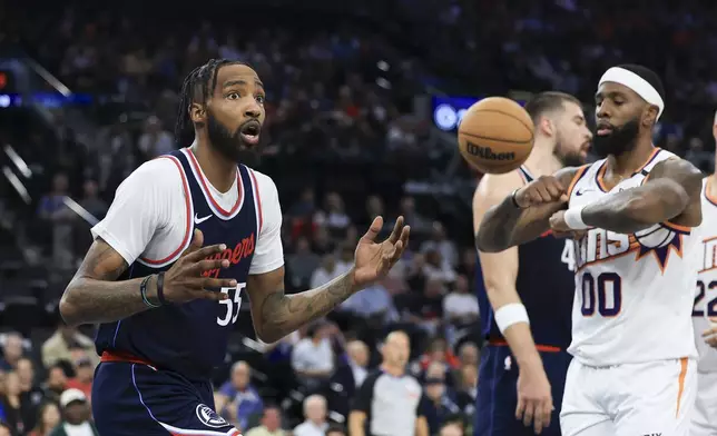 LA Clippers forward Derrick Jones Jr., left, reacts next to Phoenix Suns forward Royce O'Neale after being called for a travel during the first half of an NBA basketball game, Wednesday, Oct. 23, 2024, in Inglewood, Calif. (AP Photo/Ryan Sun)