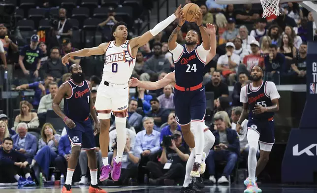 Phoenix Suns forward Ryan Dunn (0) and LA Clippers guard Norman Powell (24) vie for a loose ball during the first half of an NBA basketball game, Wednesday, Oct. 23, 2024, in Inglewood, Calif. (AP Photo/Ryan Sun)