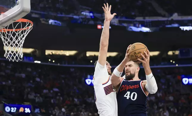 LA Clippers center Ivica Zubac, right, shoots against Phoenix Suns center Jusuf Nurkic during the first half of an NBA basketball game, Wednesday, Oct. 23, 2024, in Inglewood, Calif. (AP Photo/Ryan Sun)