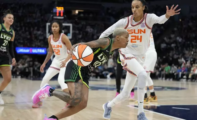 Minnesota Lynx guard Courtney Williams (10) works toward the basket as Connecticut Sun forward DeWanna Bonner (24) defends during the second half of Game 5 of a WNBA basketball semifinals, Tuesday, Oct. 8, 2024, in Minneapolis. (AP Photo/Abbie Parr)