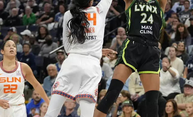 Minnesota Lynx forward Napheesa Collier, right, shoots over Connecticut Sun forward DeWanna Bonner during the second half of Game 5 of a WNBA basketball semifinals, Tuesday, Oct. 8, 2024, in Minneapolis. (AP Photo/Abbie Parr)