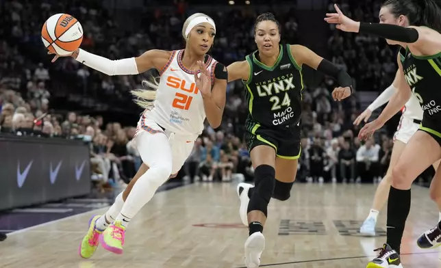 Connecticut Sun guard DiJonai Carrington (21) works toward the basket as Minnesota Lynx forward Napheesa Collier (24) defends during the first half of Game 5 of a WNBA basketball semifinals, Tuesday, Oct. 8, 2024, in Minneapolis. (AP Photo/Abbie Parr)