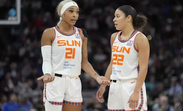 Connecticut Sun guards DiJonai Carrington (21) and Veronica Burton (22) talk during the first half of Game 5 of a WNBA basketball semifinals game against the Minnesota Lynx, Tuesday, Oct. 8, 2024, in Minneapolis. (AP Photo/Abbie Parr)