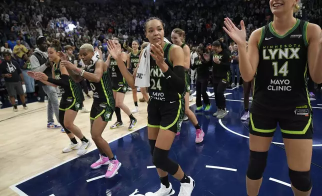 Minnesota Lynx forward Napheesa Collier (24) celebrates with teammates after the 88-77 win against the Connecticut Sun of Game 5 of a WNBA basketball semifinals, Tuesday, Oct. 8, 2024, in Minneapolis. (AP Photo/Abbie Parr)