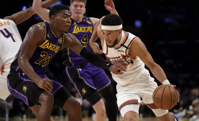 Phoenix Suns guard Devin Booker drives against Los Angeles Lakers forward Rui Hachimura (28) during the first half of an NBA basketball game against the in Los Angeles, Friday, Oct. 25, 2024. (AP Photo/Eric Thayer)