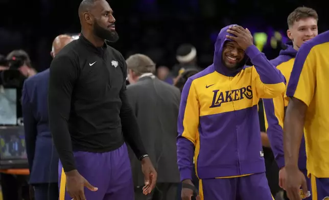 Los Angeles Lakers forward LeBron James, left, and his son, guard Bronny James warm up prior to an NBA basketball game against the Phoenix Suns in Los Angeles, Friday, Oct. 25, 2024. (AP Photo/Eric Thayer)